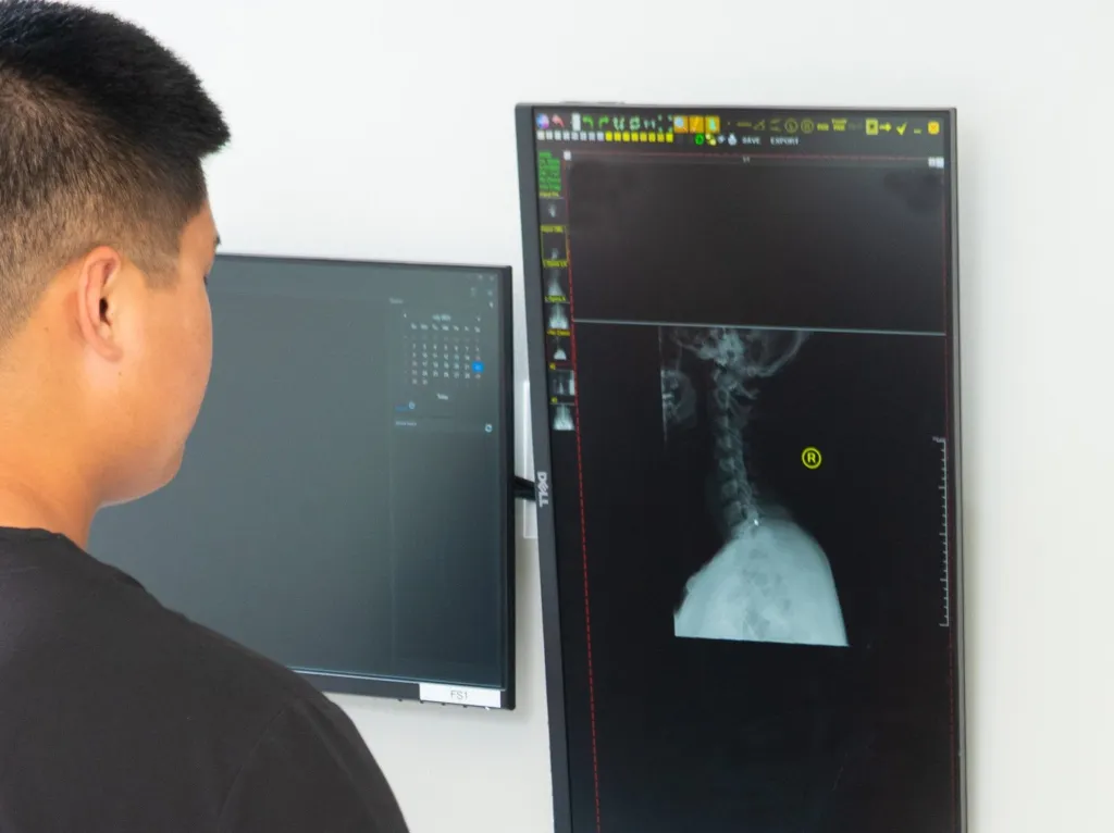 Dr. Christopher On evaluating patient care at On With Life Chiropractic Lenexa
